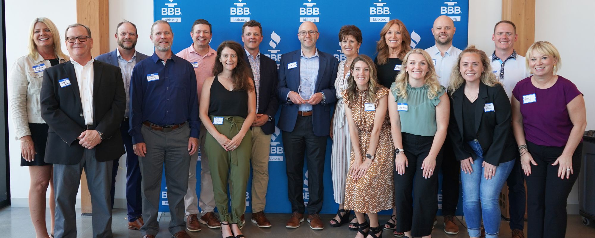 Group of employee owners sharing the award trophy